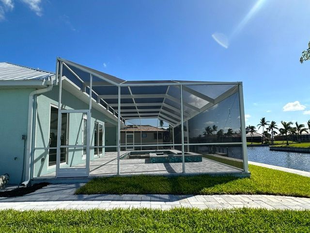 Screened patio enclosure beside a pool on a sunny day