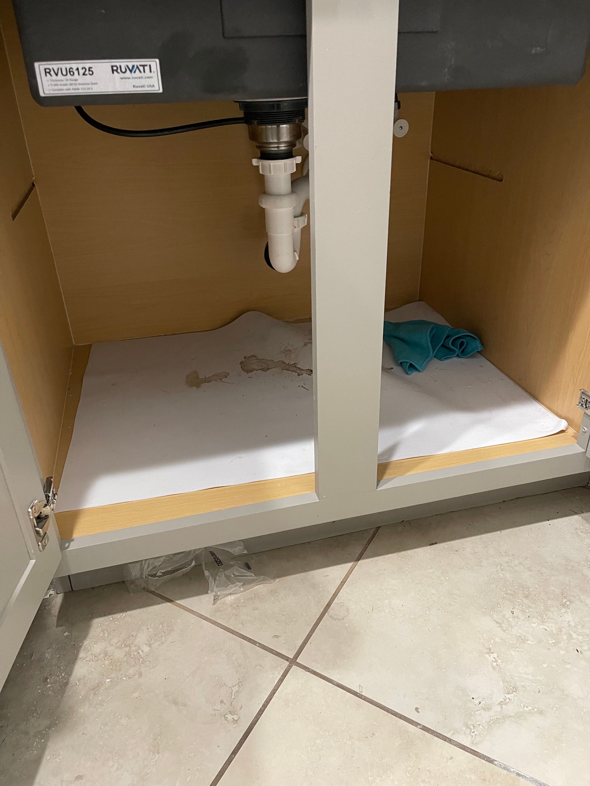 A bathroom sink with a white mat underneath it.
