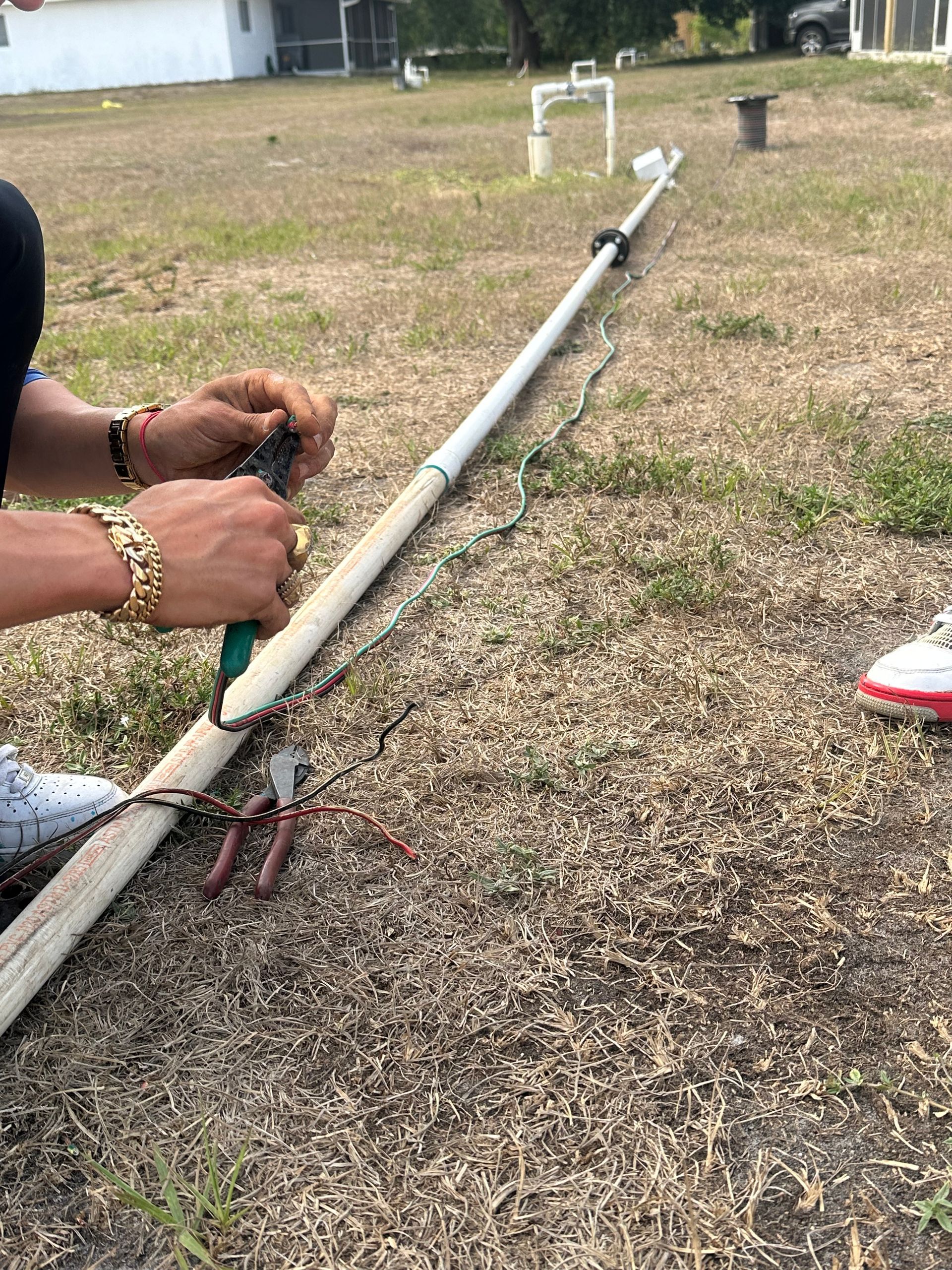 A person is working on a pipe in a field.