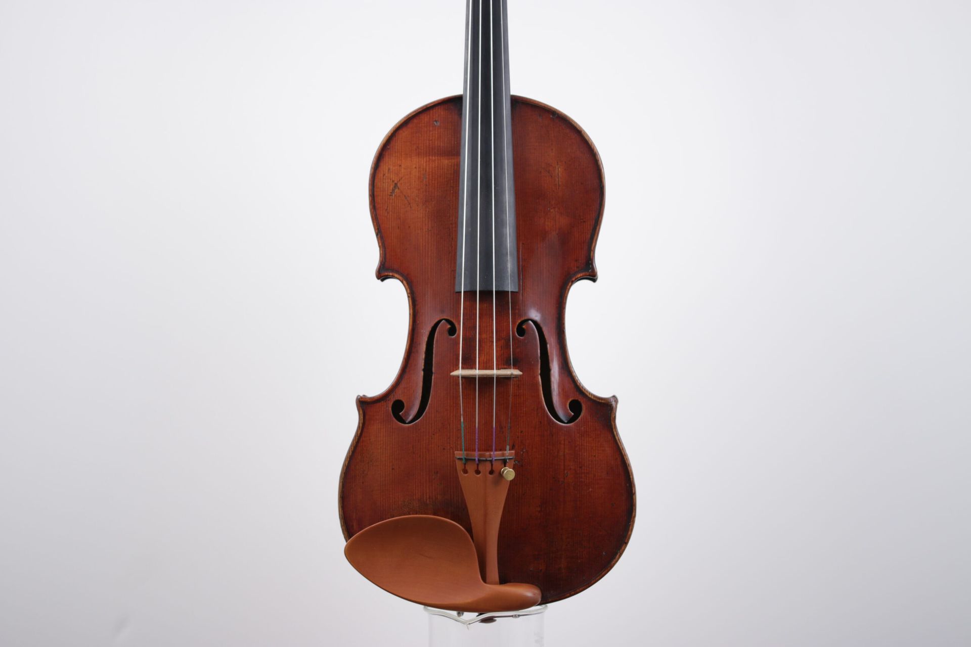 A violin is sitting on a white surface.