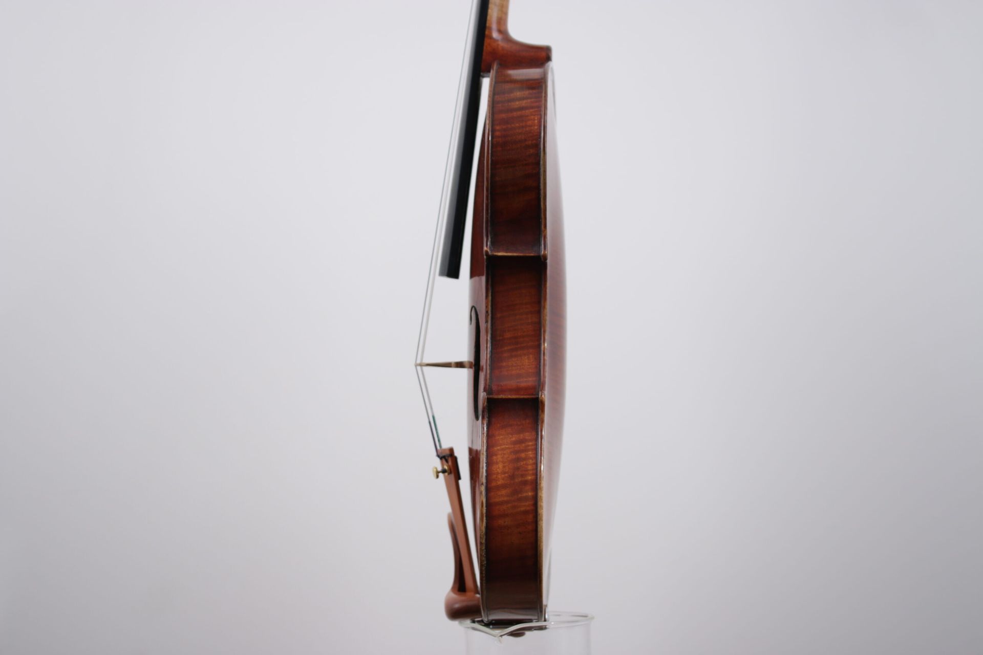 A close up of a violin with a bow on a white background.