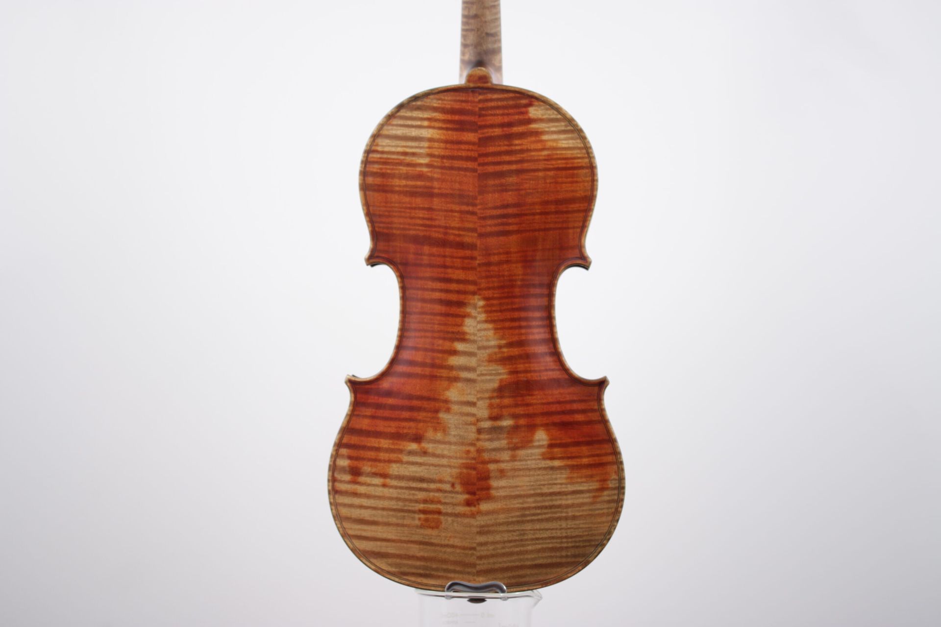 A person is repairing a violin with a piece of wood.