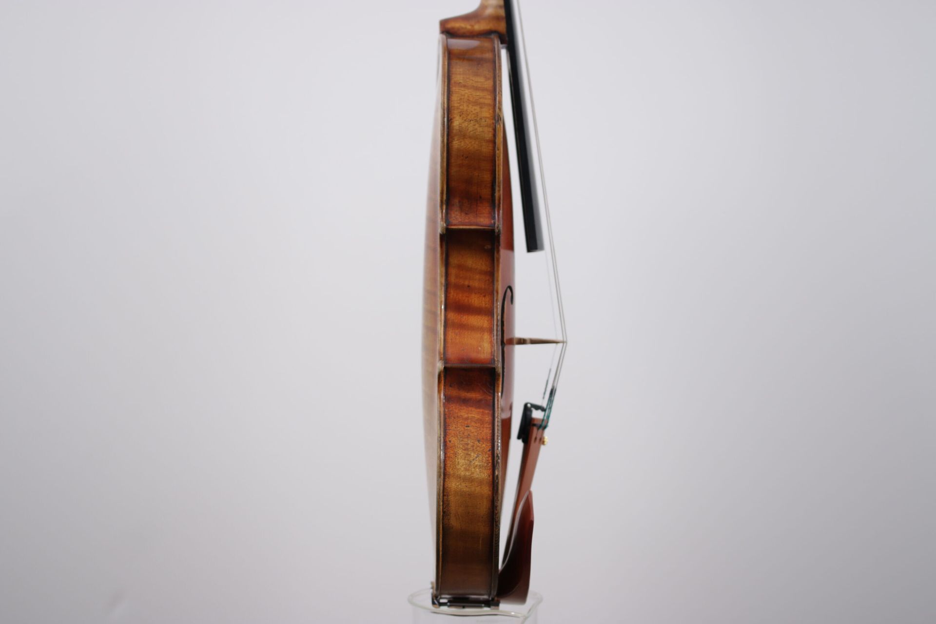 A close up of a violin with a bow on a white background.