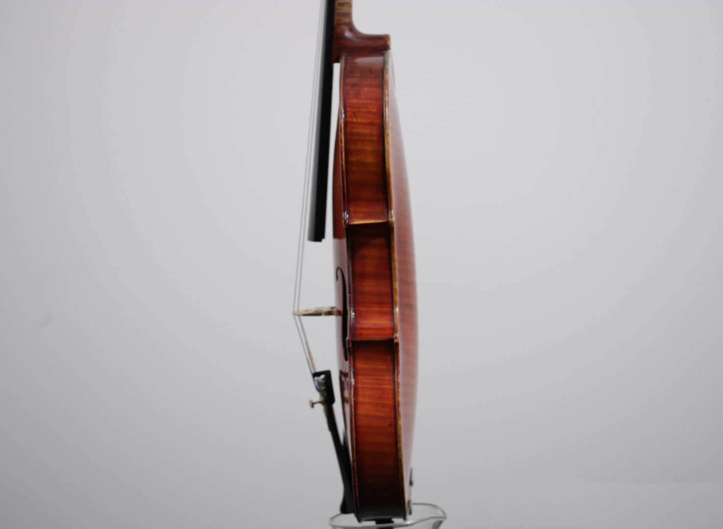 A violin is sitting on a stand with a white background