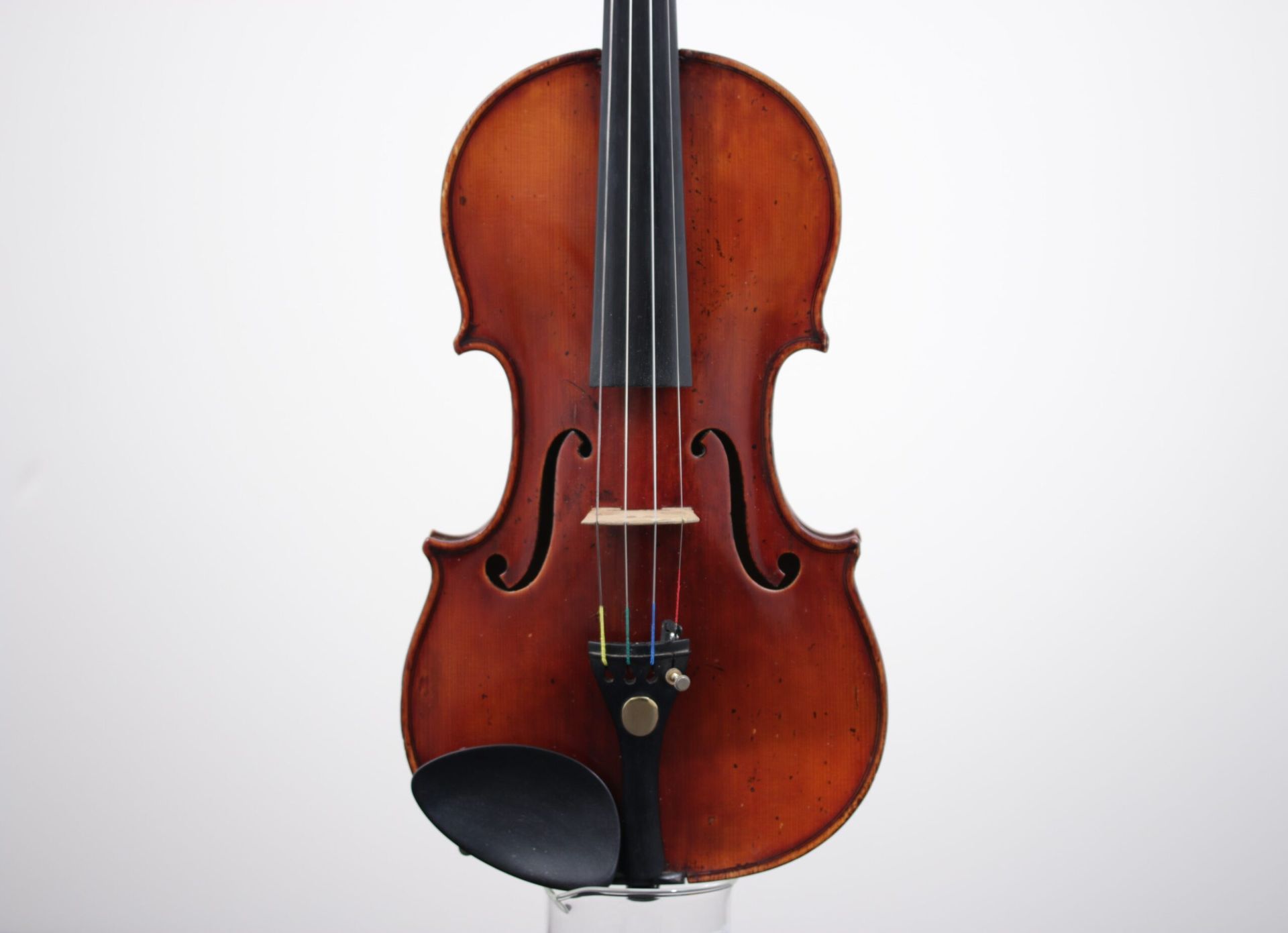 A violin is sitting on a white surface