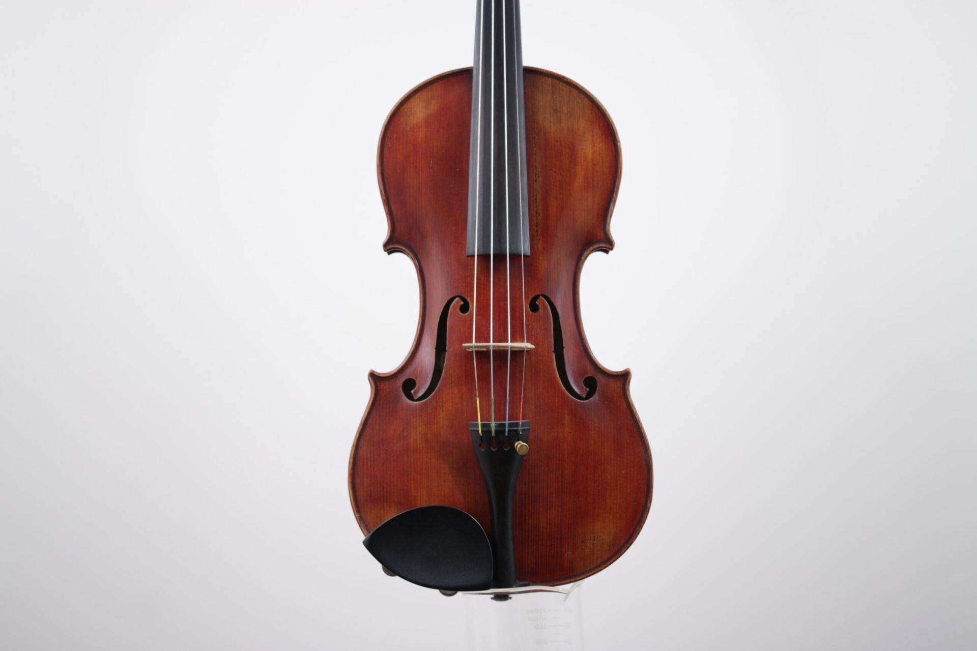 A violin is sitting on a white surface