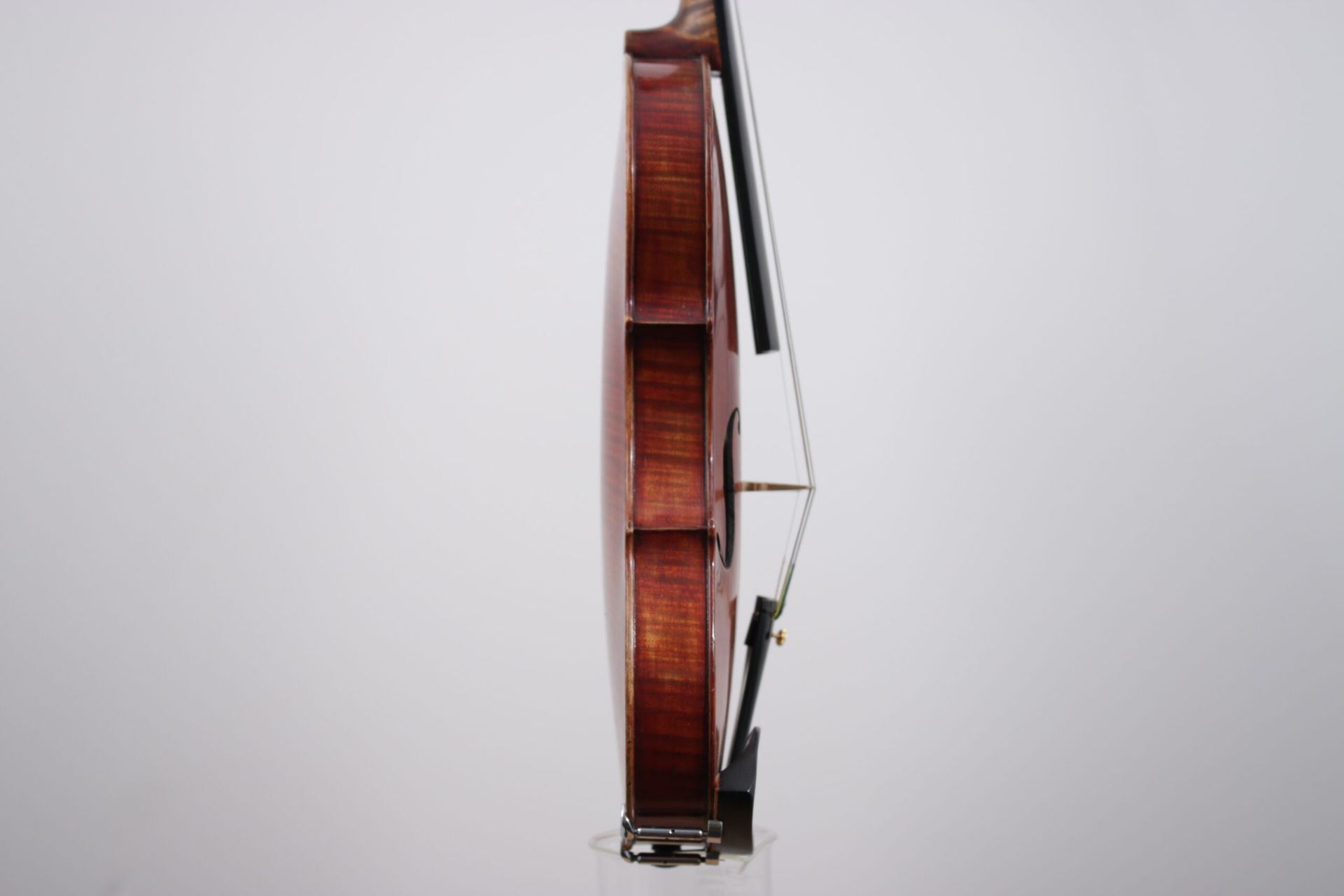 A close up of a violin with a bow on a white background.