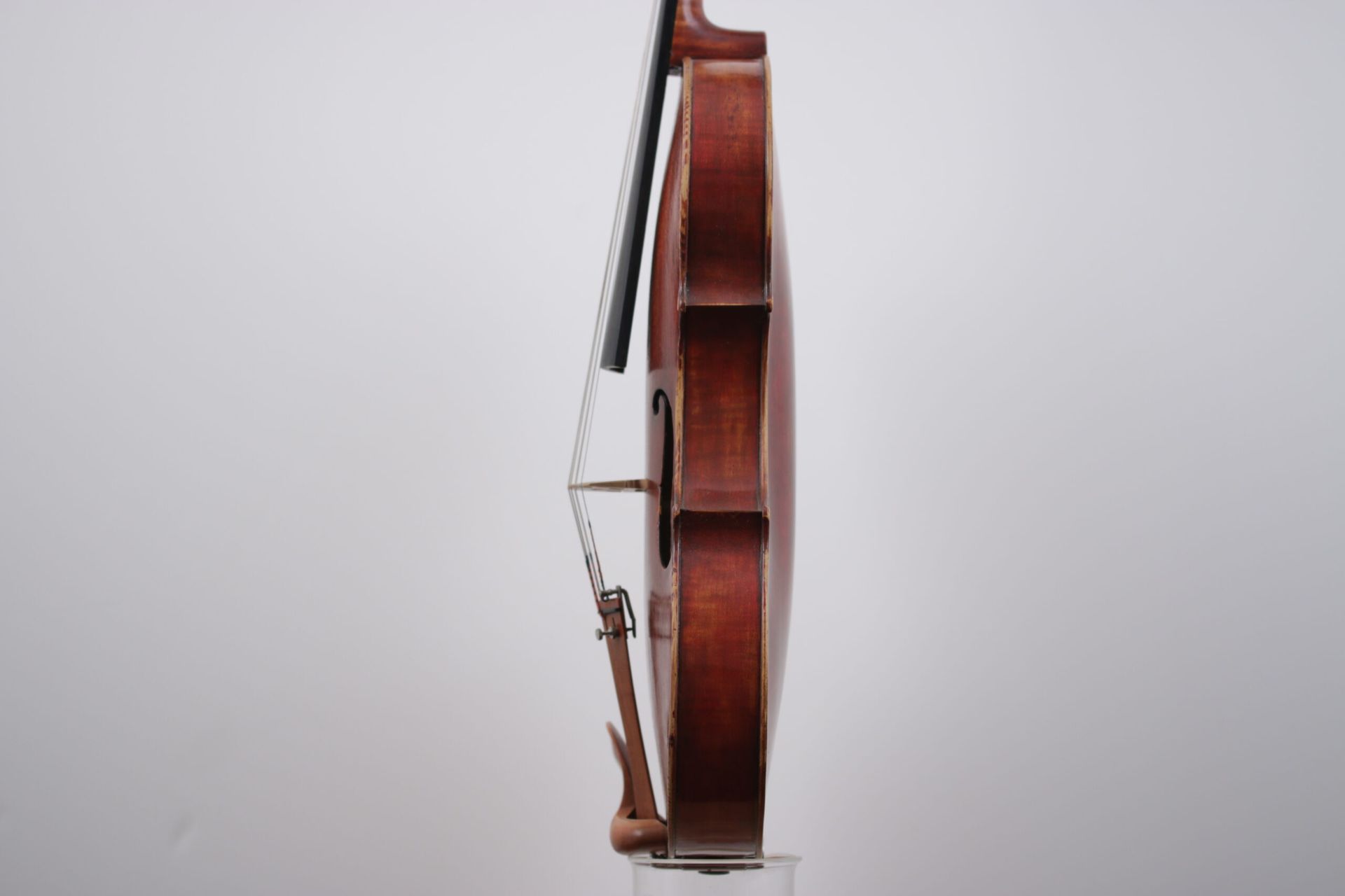 A violin with a bow is sitting on a white surface.