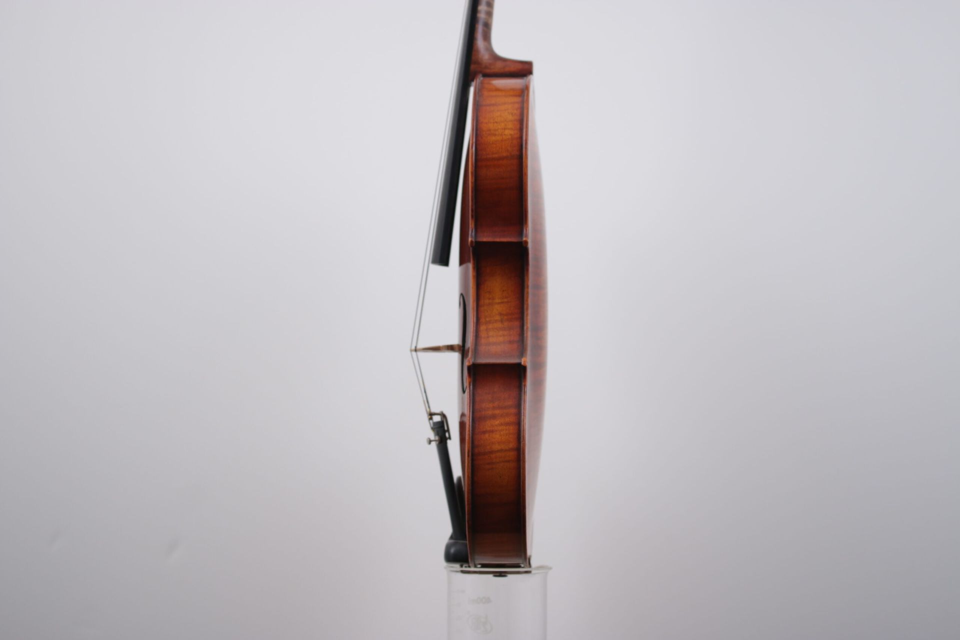 A violin is leaning against a white wall