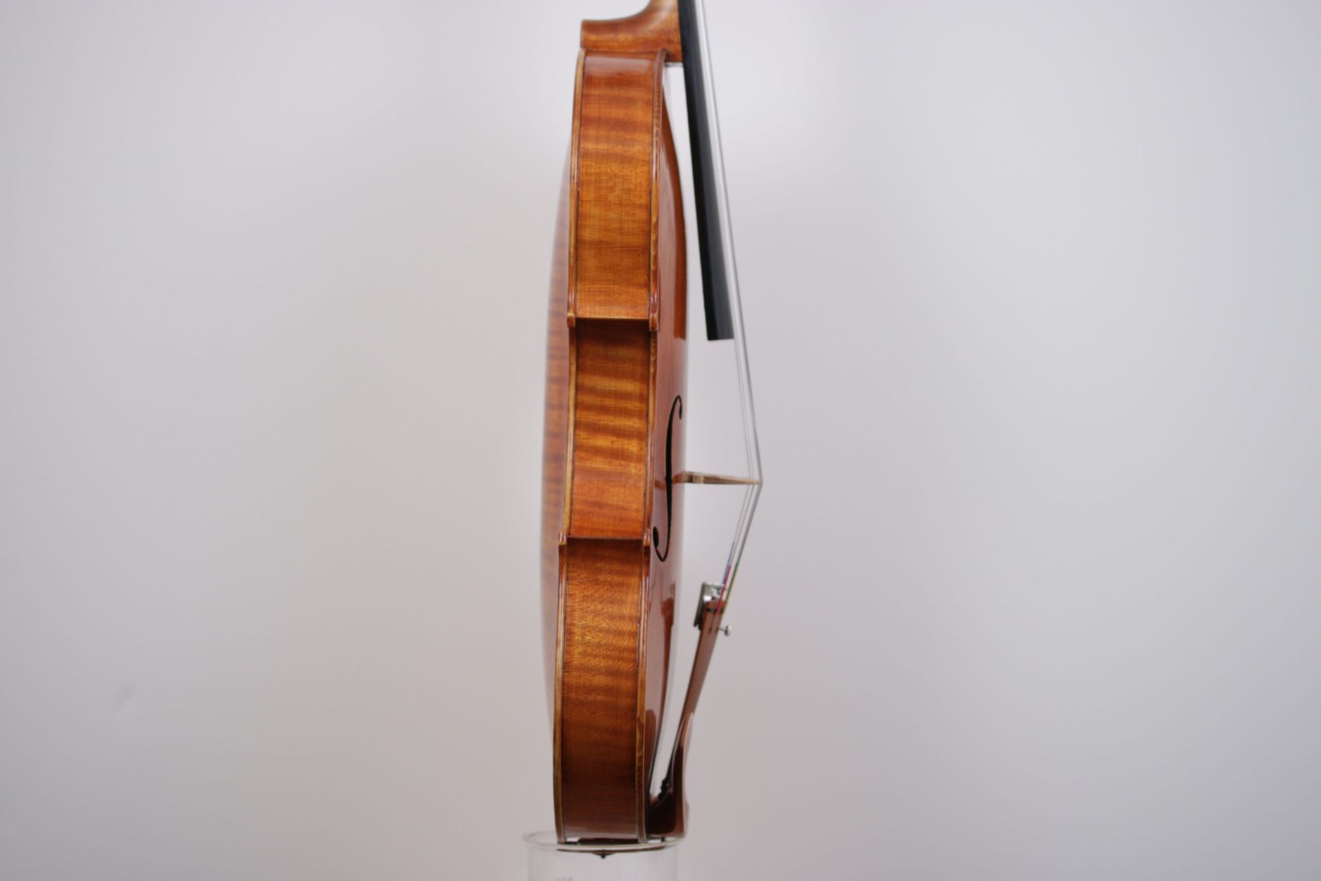 A close up of a violin with a bow on a white background.
