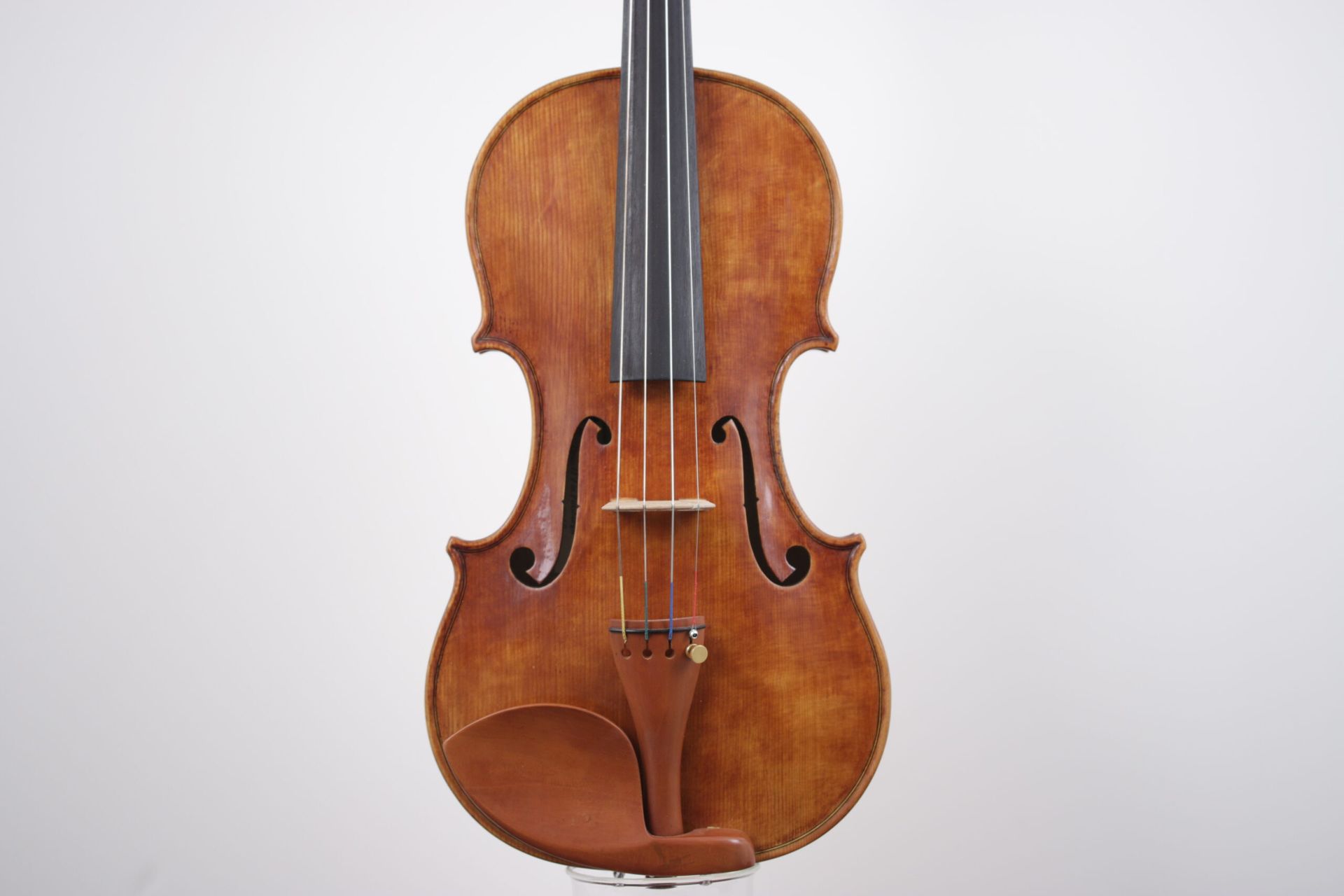 A violin is sitting on a white surface.