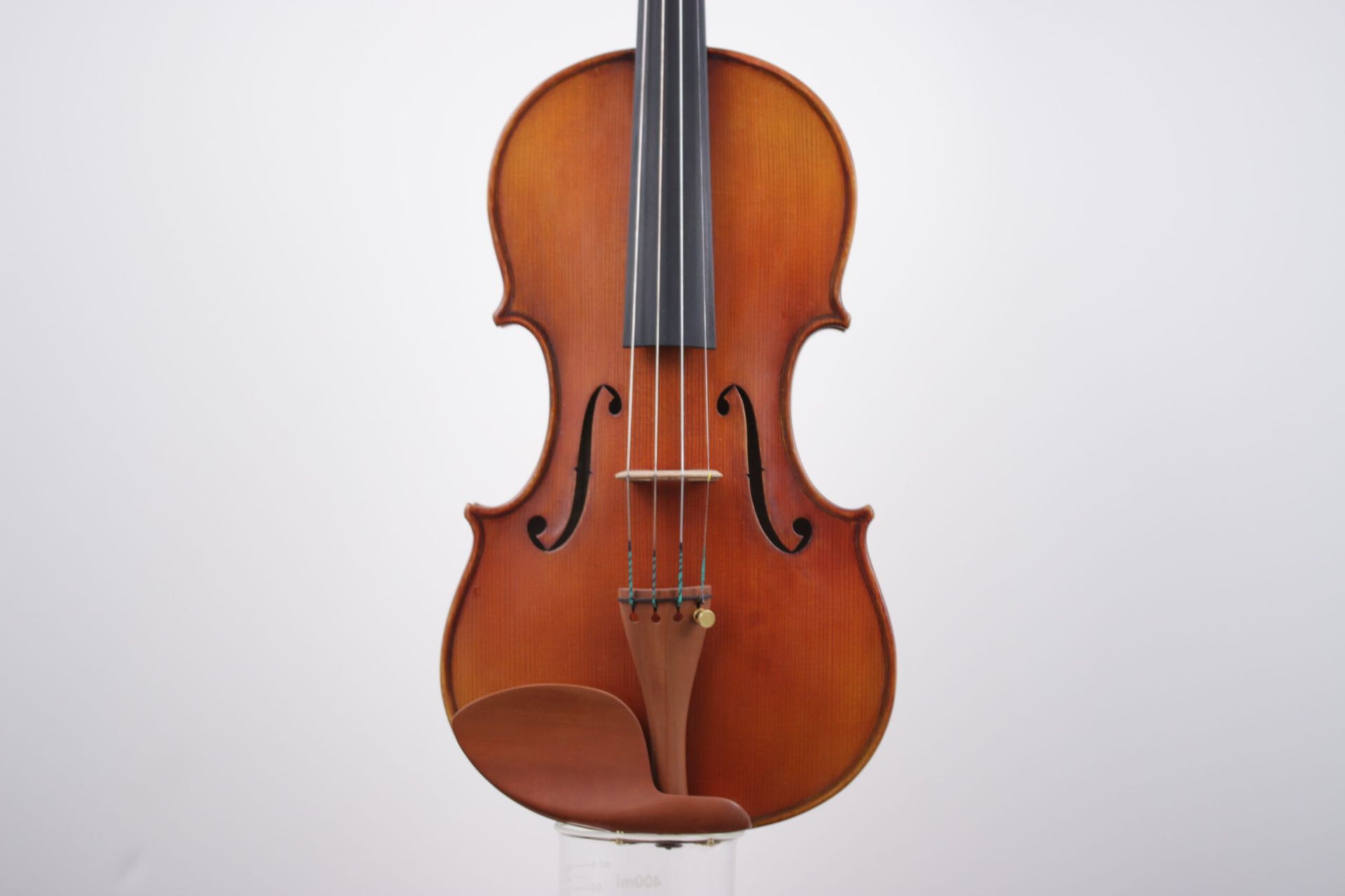 A violin is sitting on a white surface.