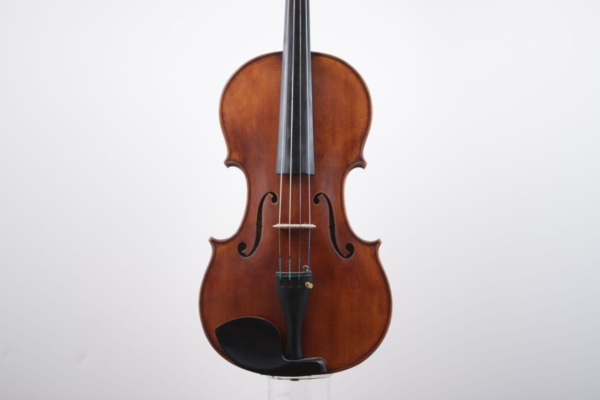 A violin is sitting on a white surface