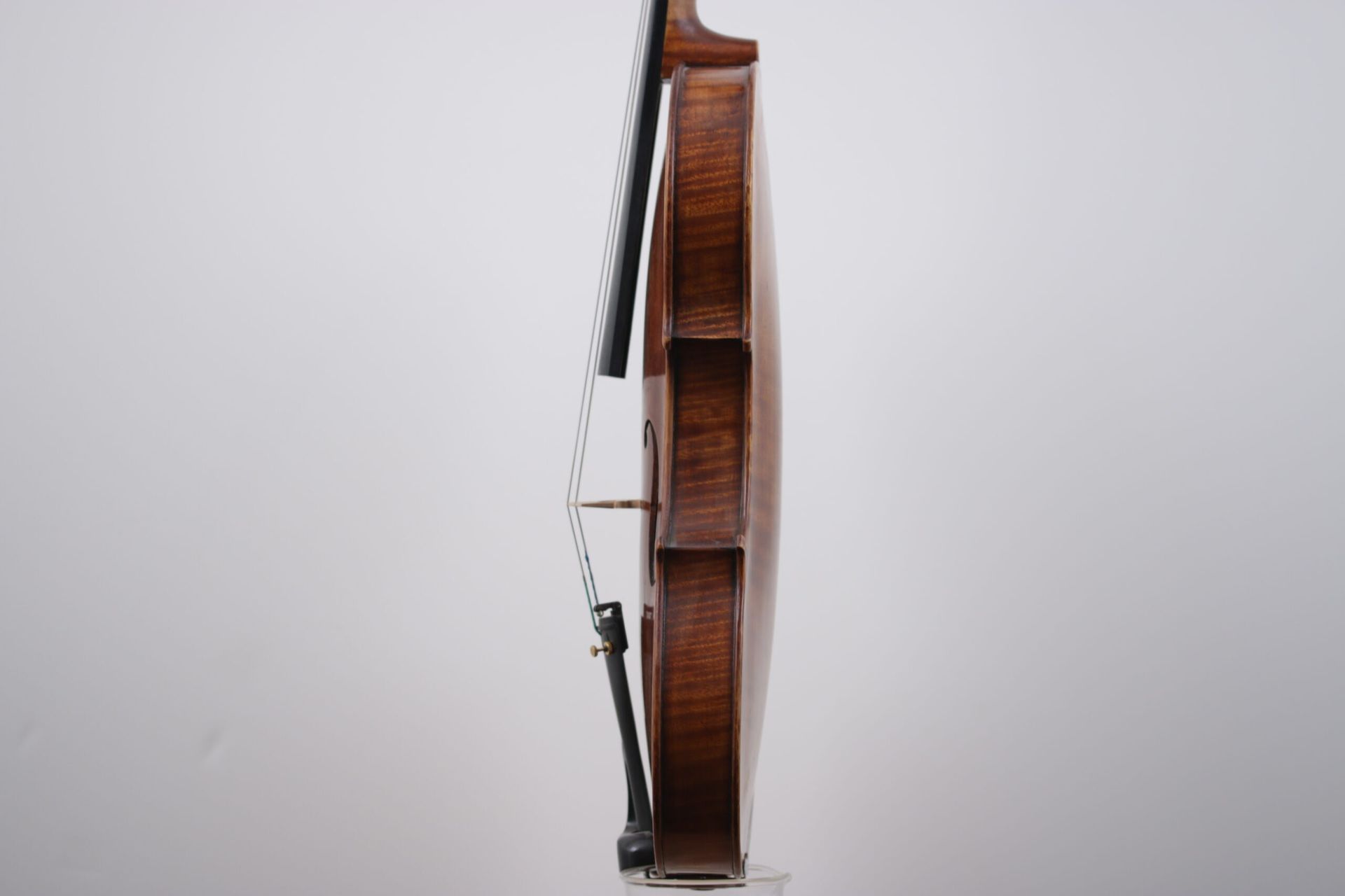 A violin is sitting on a white surface.