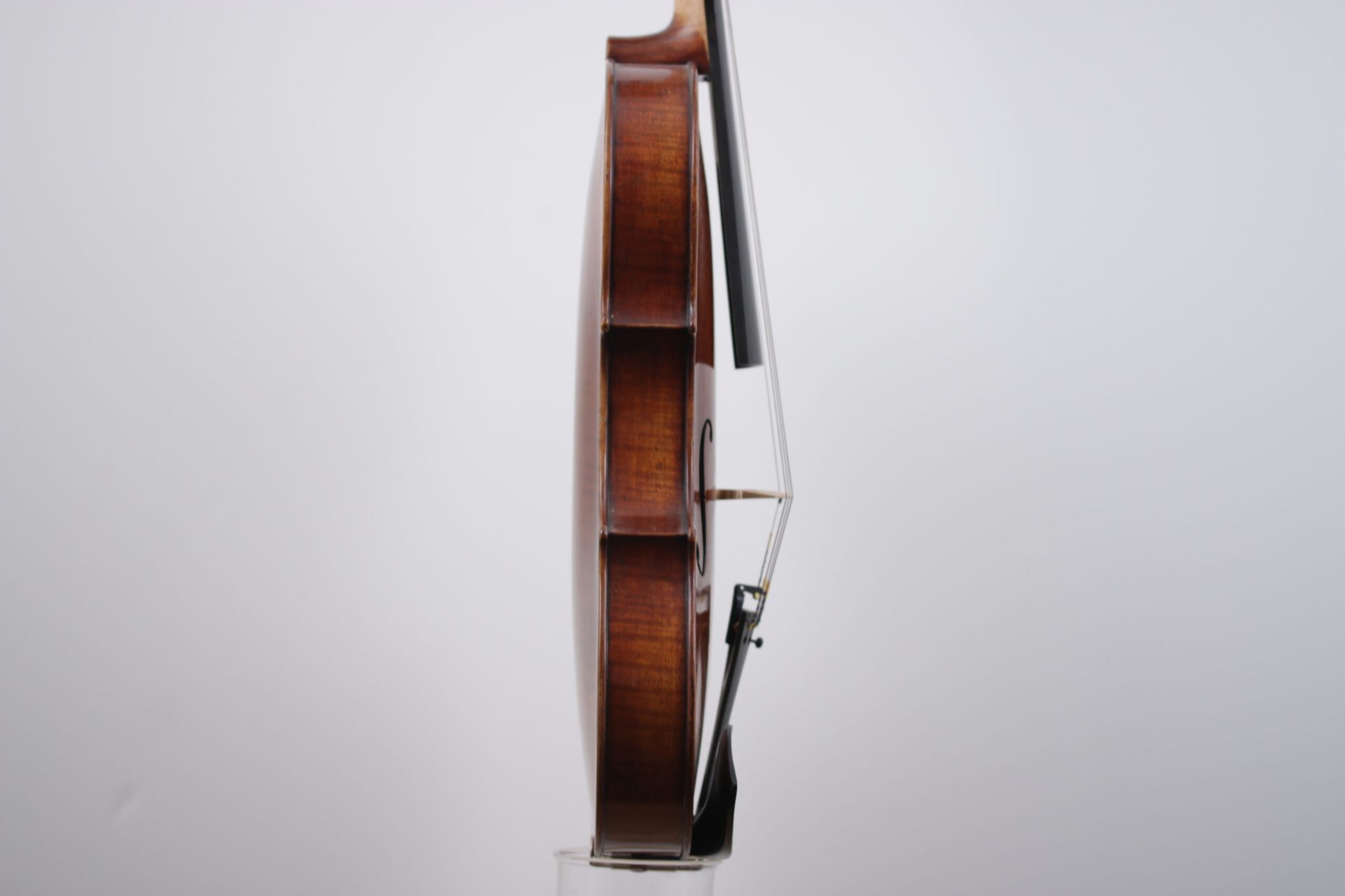 A violin with a bow is sitting on a white surface.