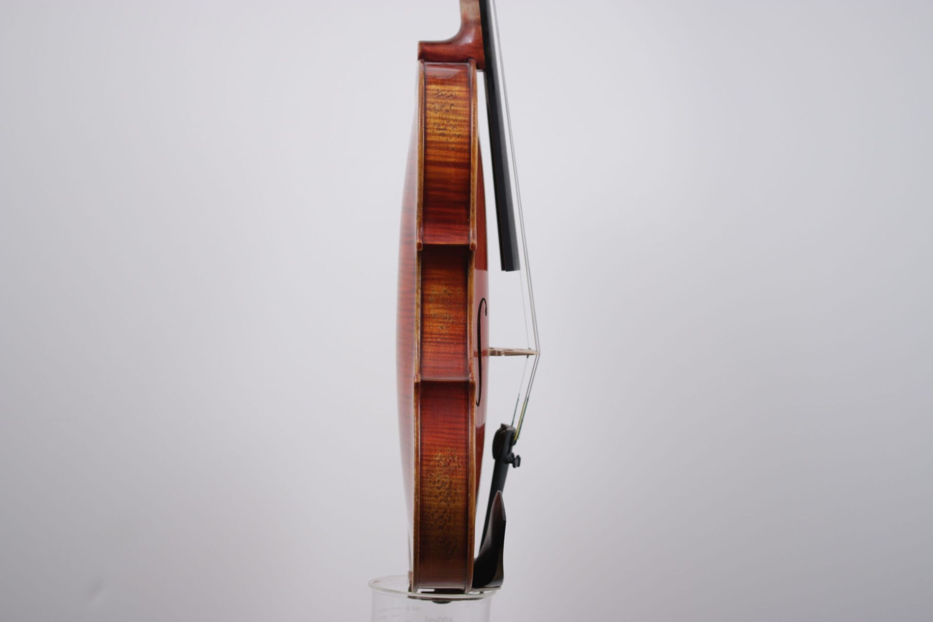 A violin with a bow is sitting on a white surface.