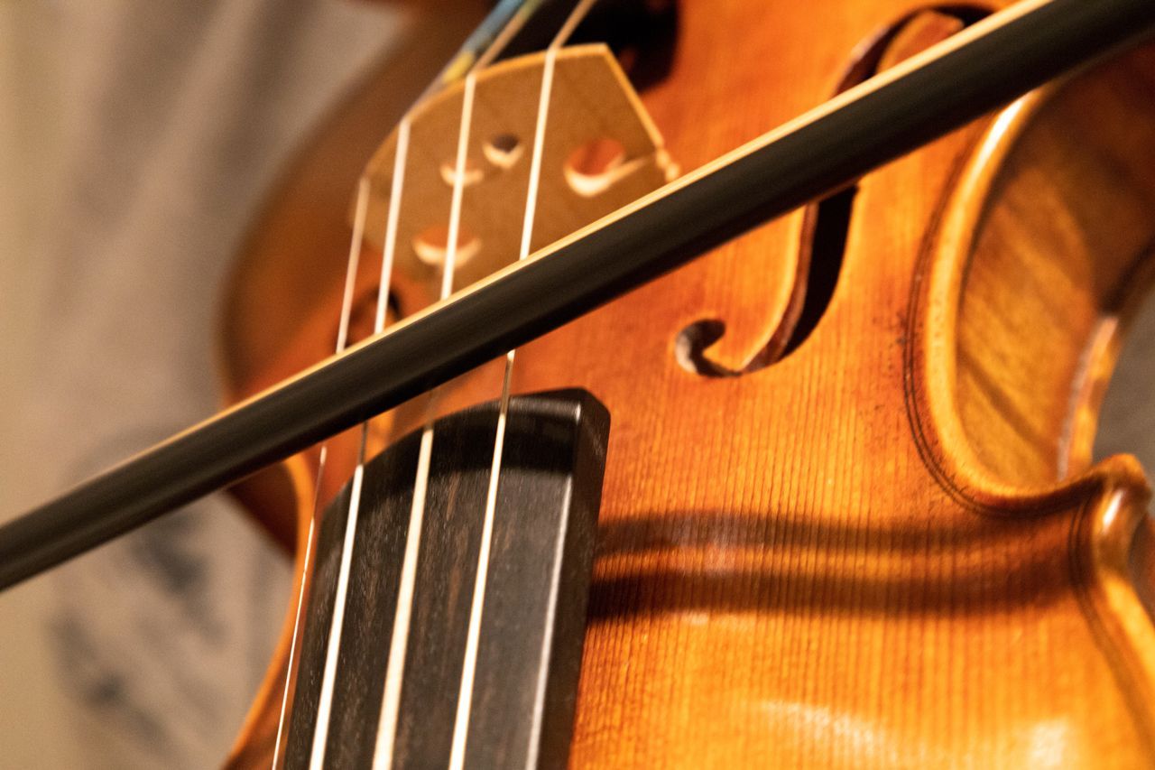 A person is playing a violin with a bow.