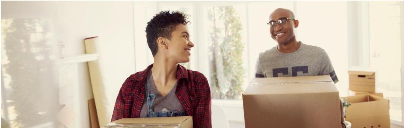 A man and a woman are standing next to each other holding cardboard boxes.