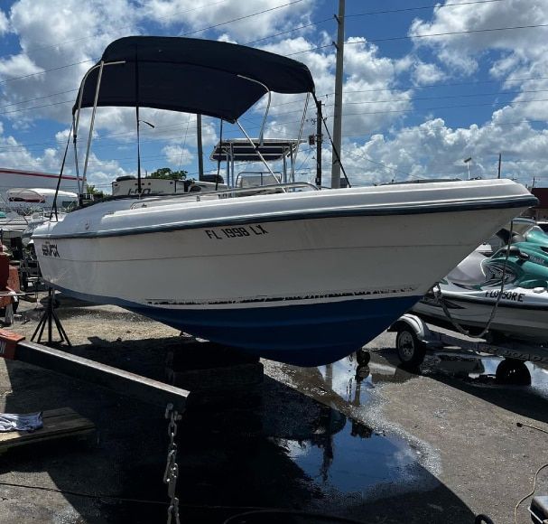 A white boat with a blue hull and florida license plate