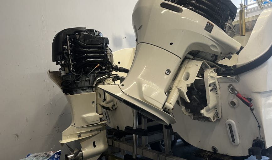 A white outboard motor is sitting on top of a white boat.