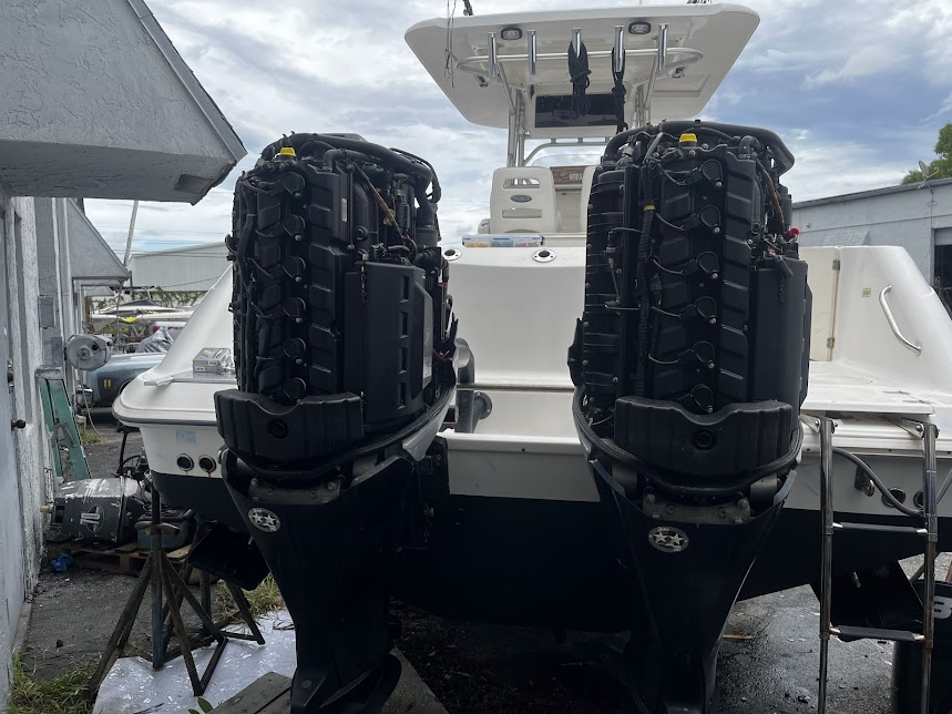 A boat with two outboard engines is parked in front of a building.