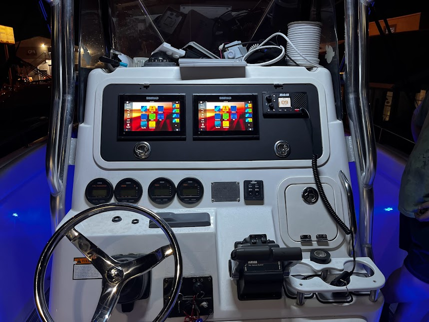 A boat with a steering wheel and two monitors on it
