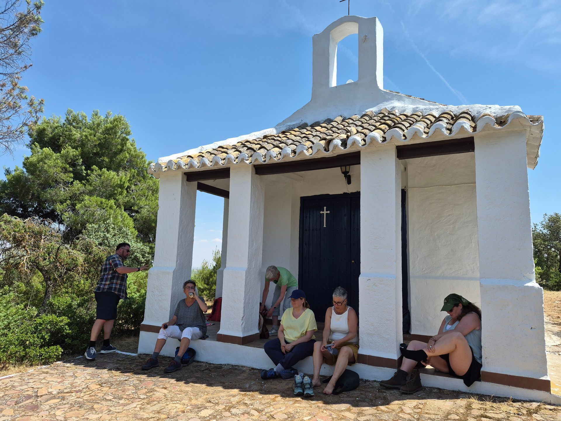 een aantal retraitegangers zit voor een kapelletje in castilla la mancha