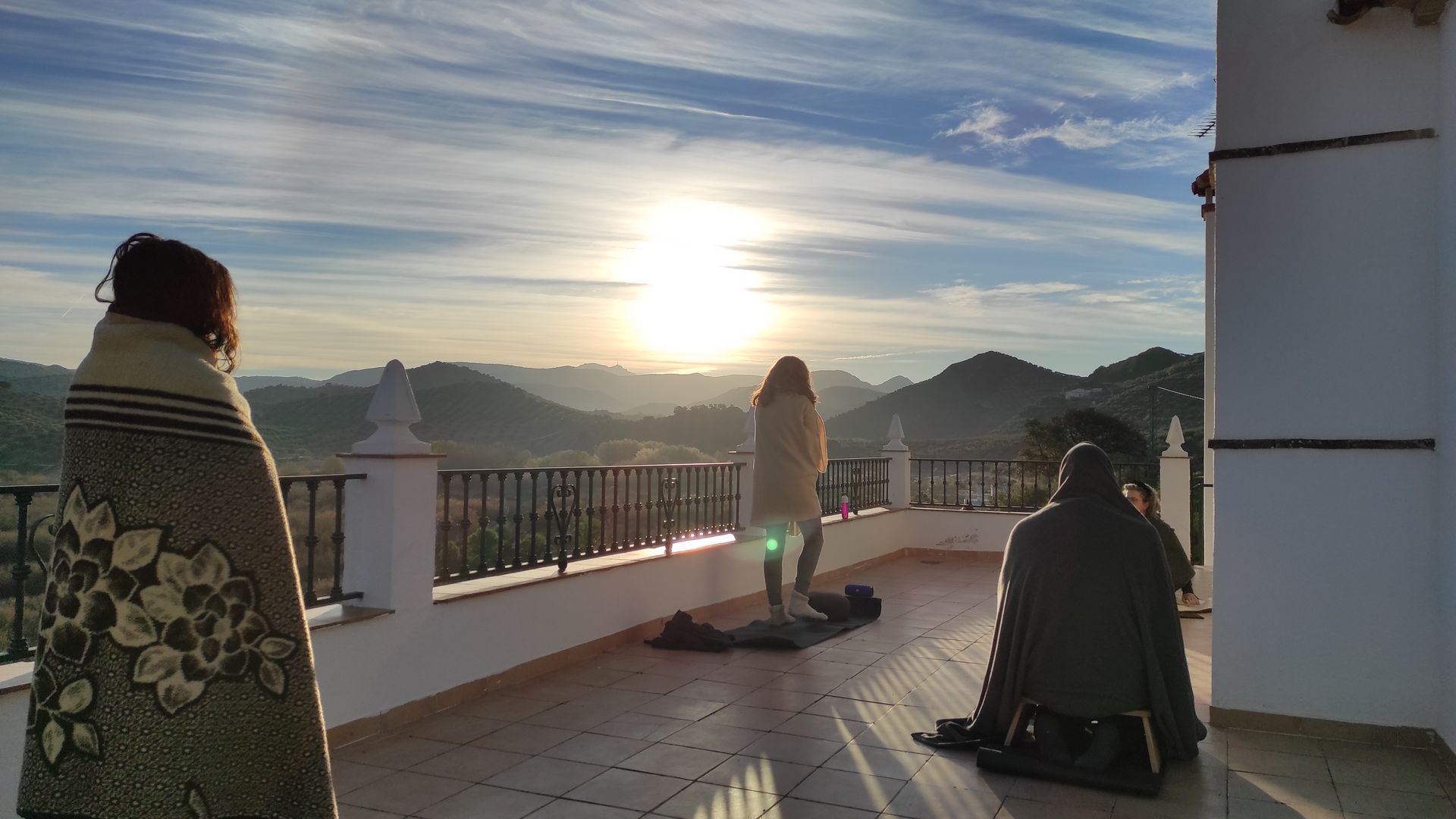 op een dakterras in spanje openen retraitedeelnemers de dag bij opkomende zon