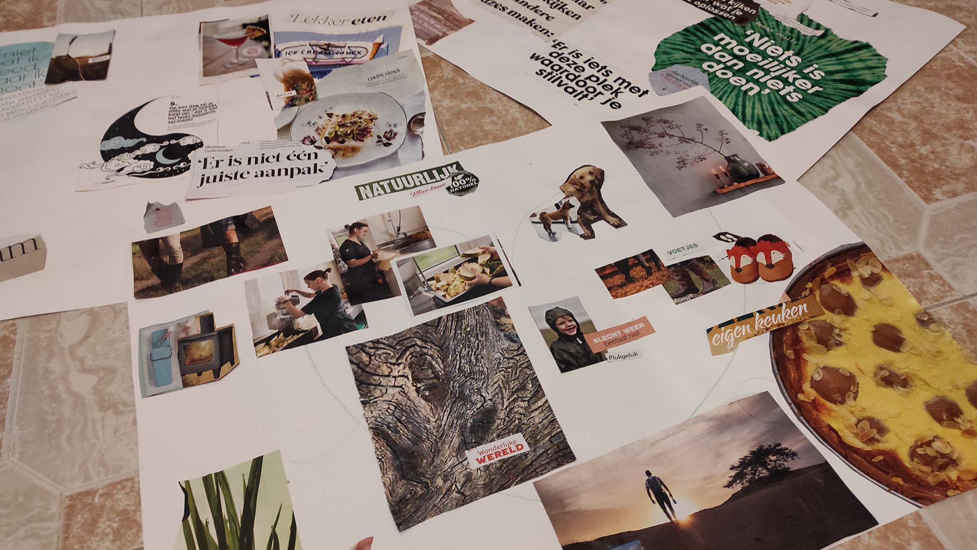 Een collage van afgedrukte foto's, tekstfragmenten en tekeningen, gerangschikt op witte papieren oppervlakken.