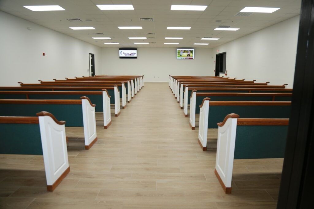 Empty church sanctuary with rows of wooden pews and a central aisle