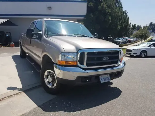 Silver Ford pickup truck parked outside a building on a sunny day