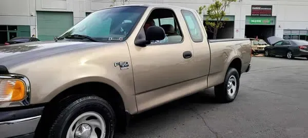 Beige pickup truck parked on a street near buildings