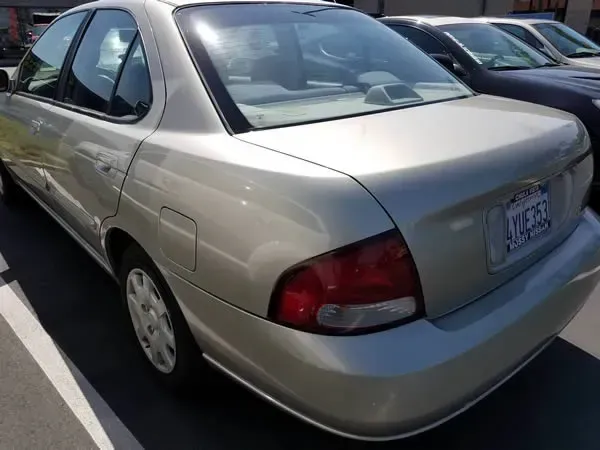 Silver sedan parked in a lot, viewed from the rear-left side.