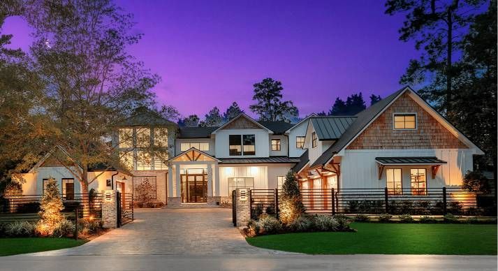 A large house with a lot of windows is lit up at night.
