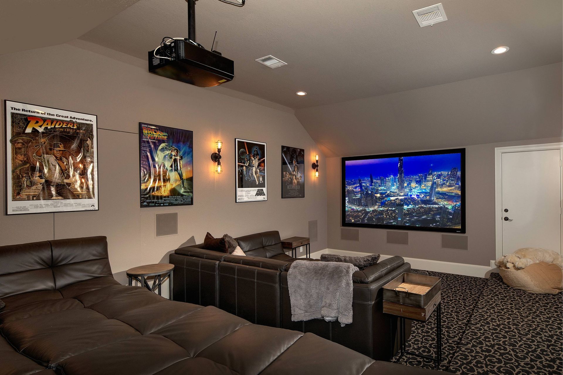 A home theater with a large flat screen tv and a projector.