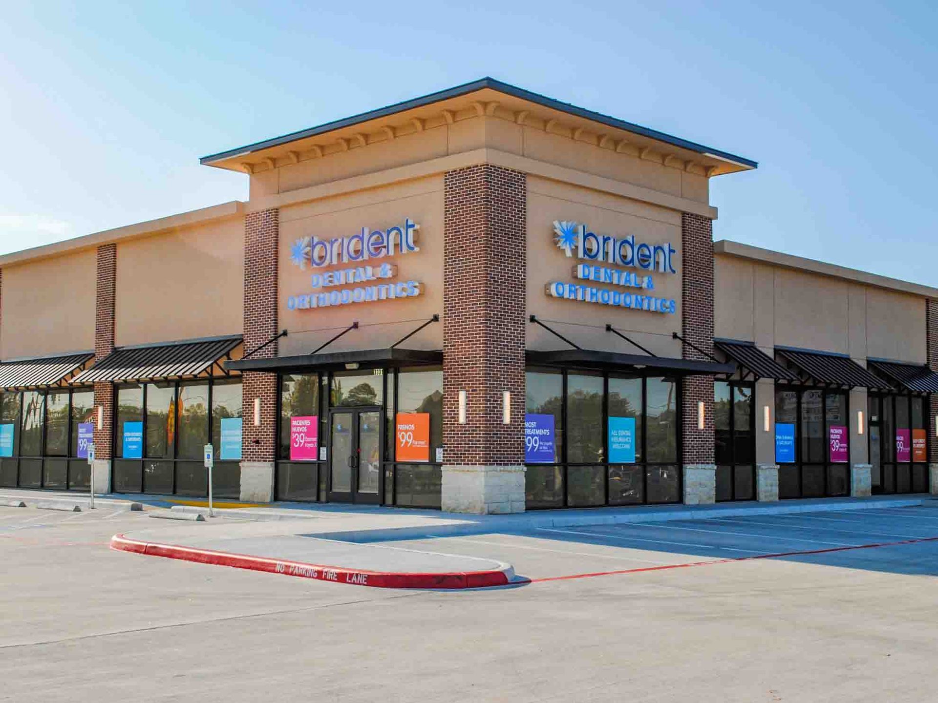 A large brick building with a lot of windows and a parking lot in front of it.