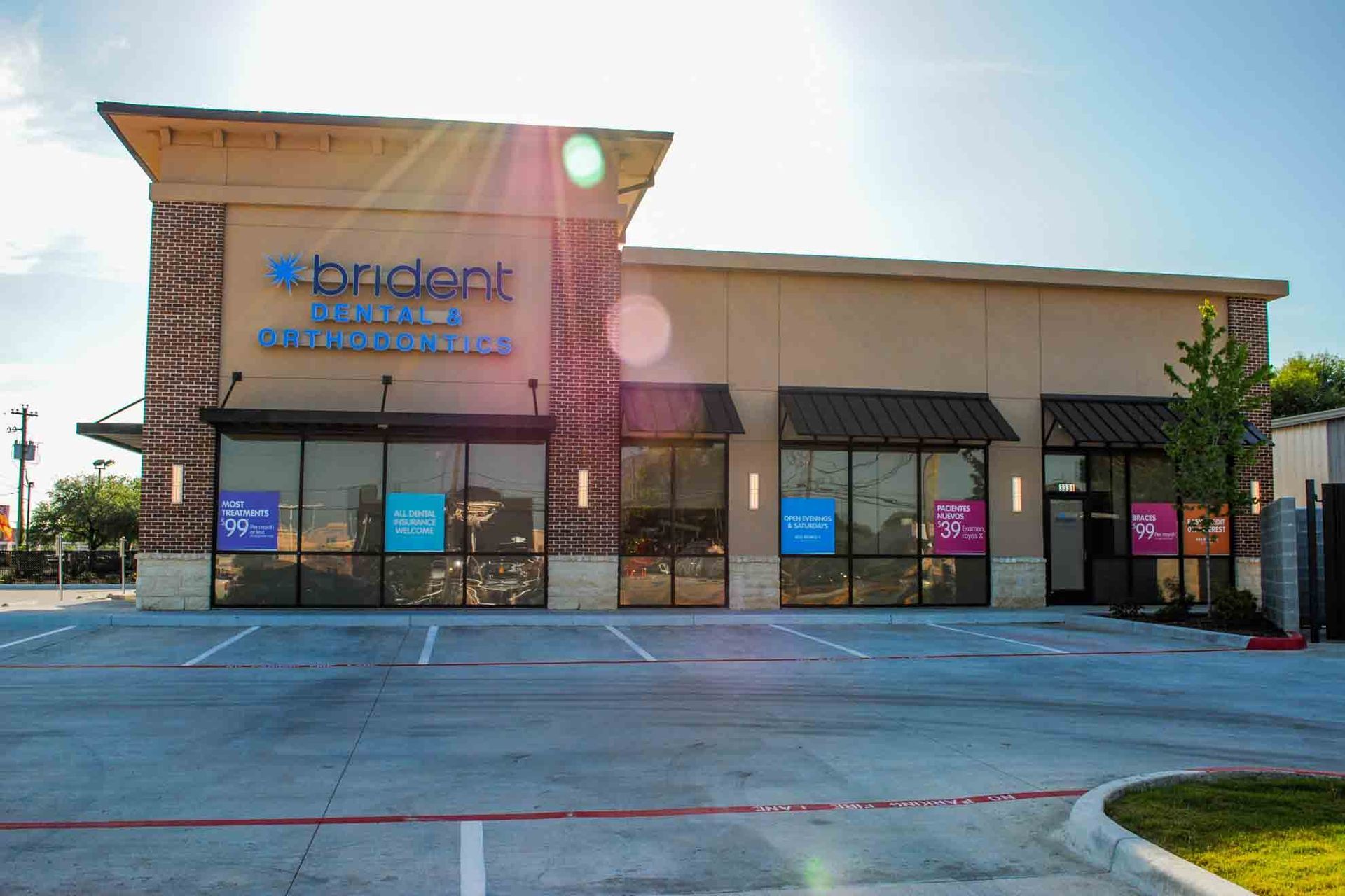 A large building with a lot of windows and a parking lot in front of it.