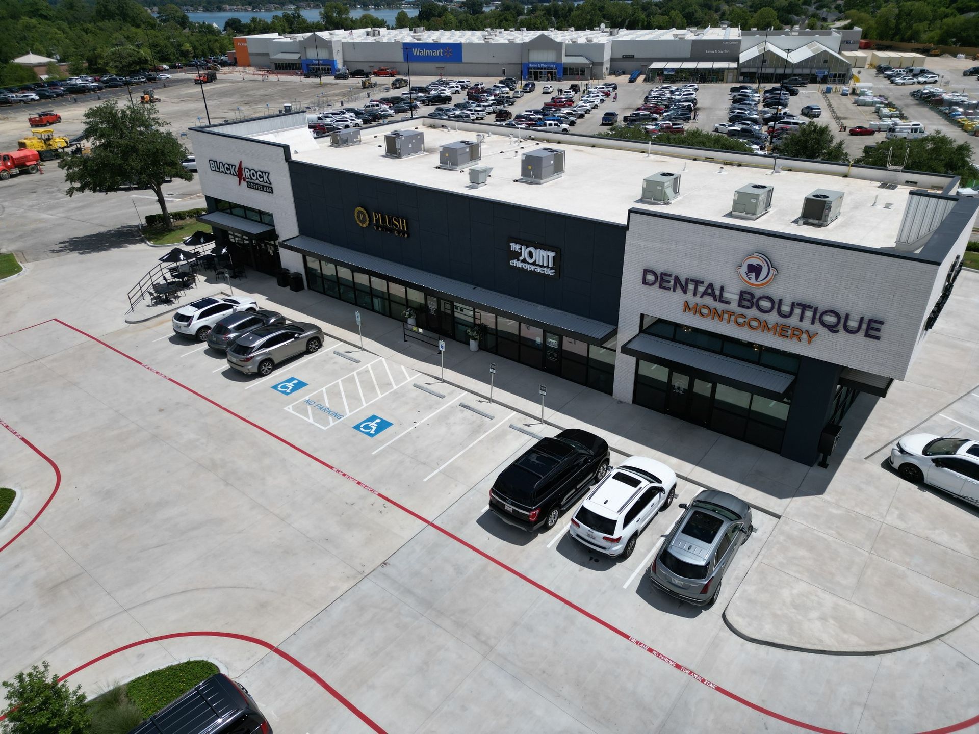 An aerial view of a dental boutique with cars parked in front of it.