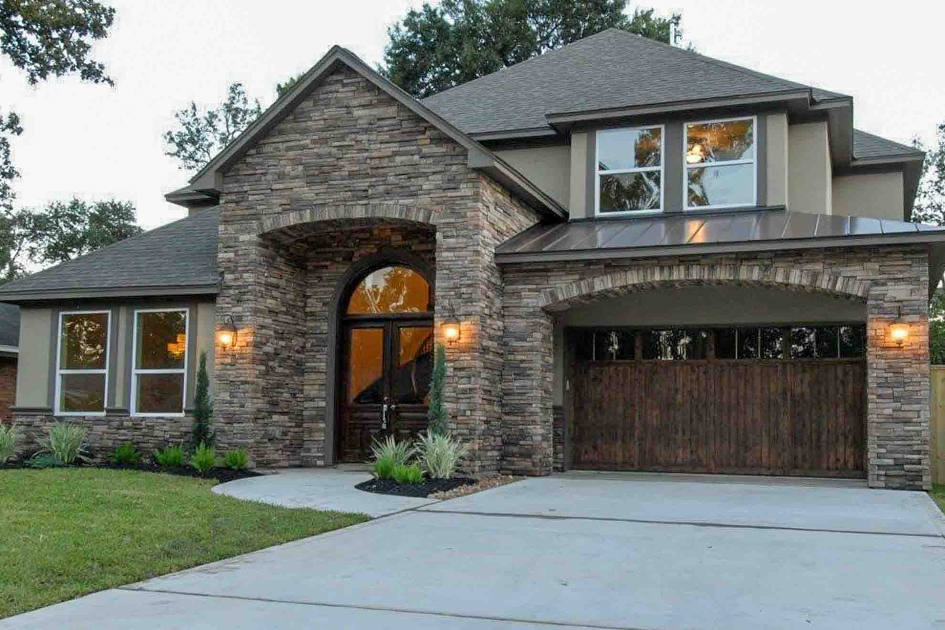 A large house with a stone facade and a wooden garage door