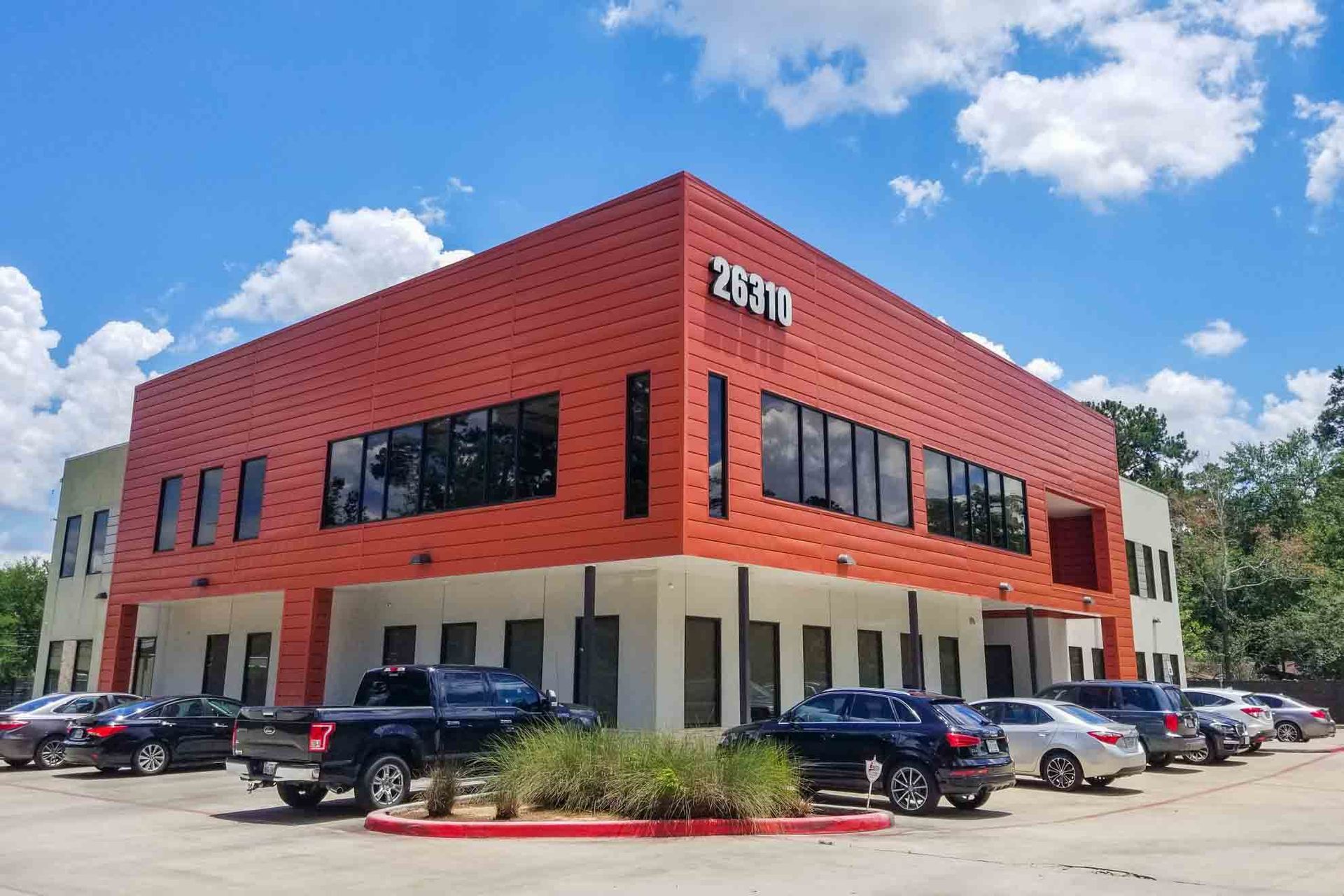 A large building with a lot of cars parked in front of it.