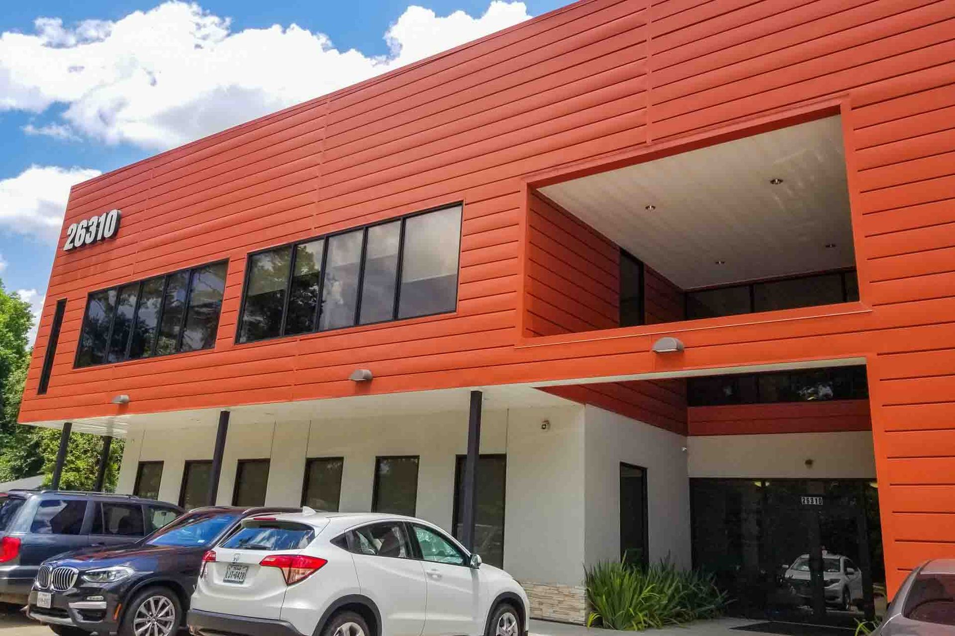 A large orange building with cars parked in front of it.