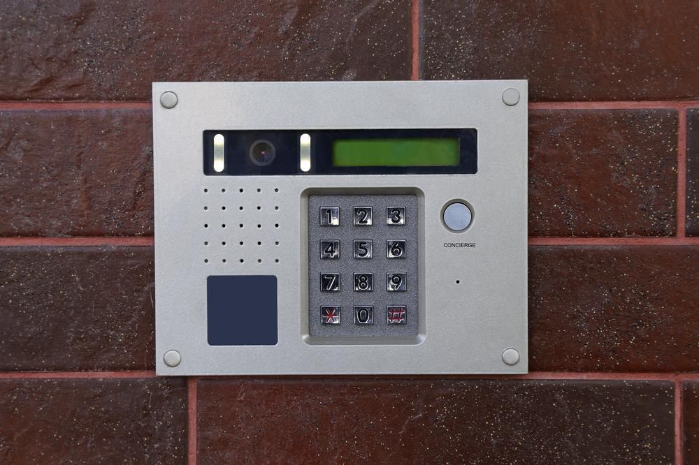 A Keypad on A Brick Wall with A Green Screen — MNC Security in Emerald Beach, NSW