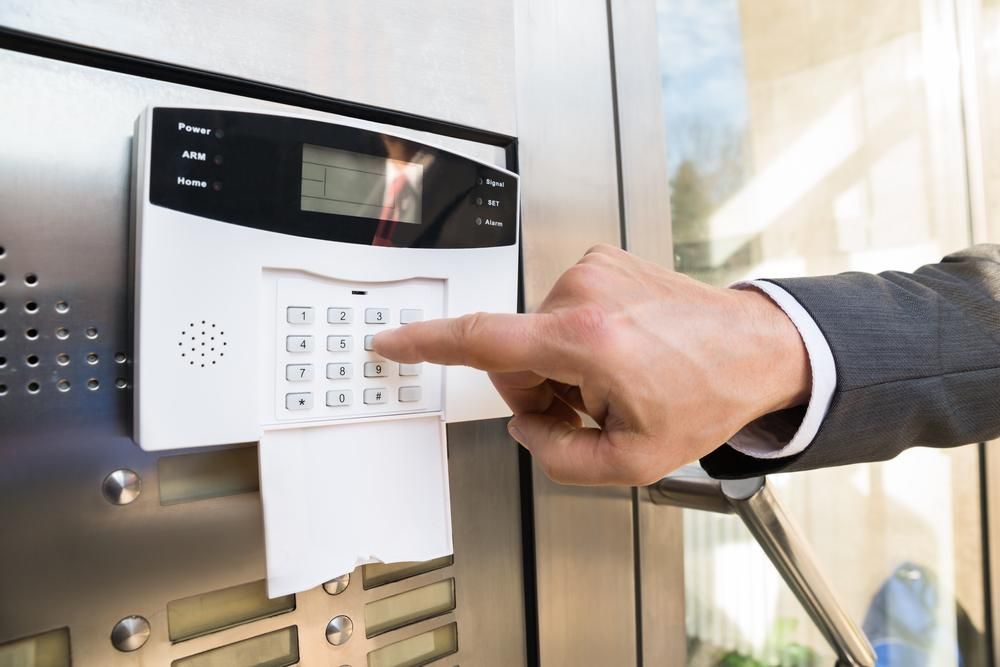 A Person Is Pressing a Button on A Security System — MNC Security in Sandy Beach, NSW