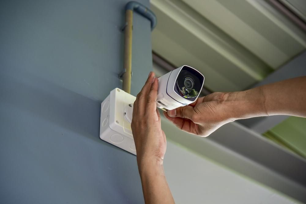 A Person Is Installing a Security Camera — MNC Security in Sandy Beach, NSW