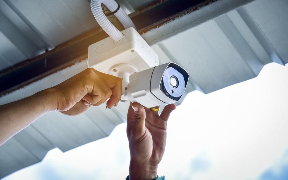 A Person Is Installing a Security Camera — MNC Security in Sapphire Beach, NSW