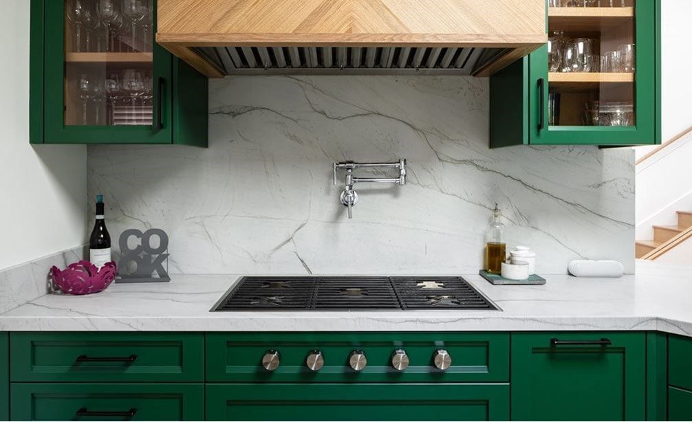A man is fixing an oven in a kitchen.