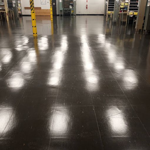 A warehouse with a shiny floor and a yellow pole