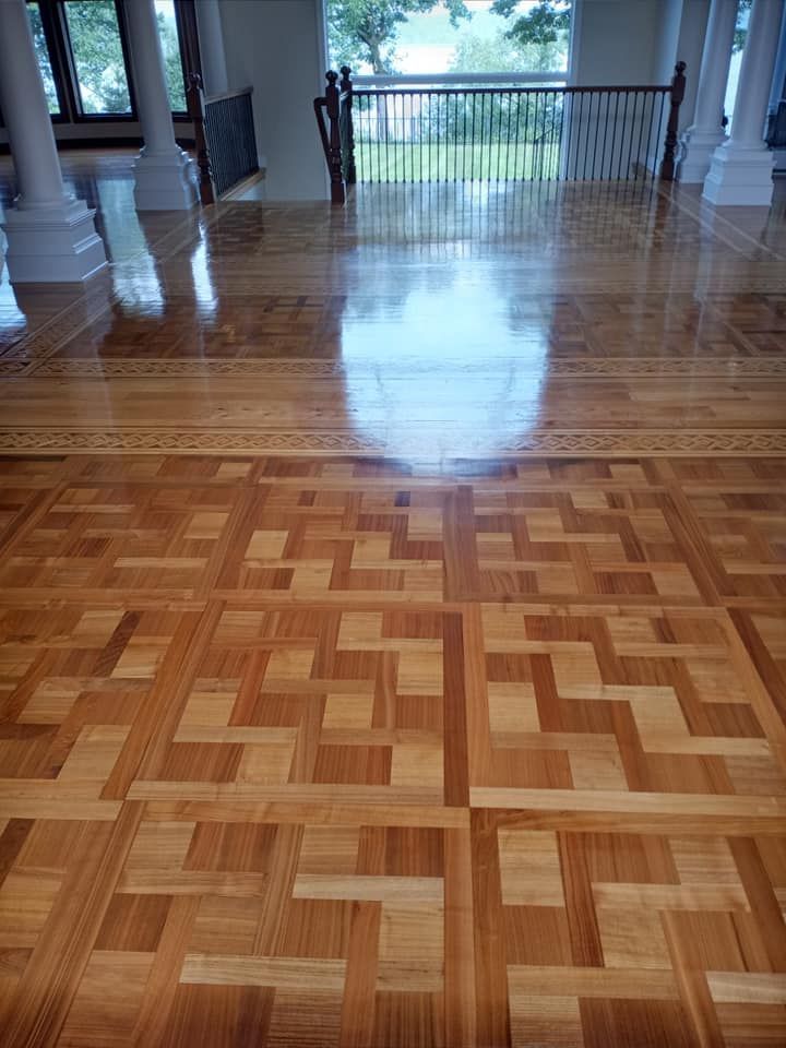A large room with a wooden floor and a staircase.
