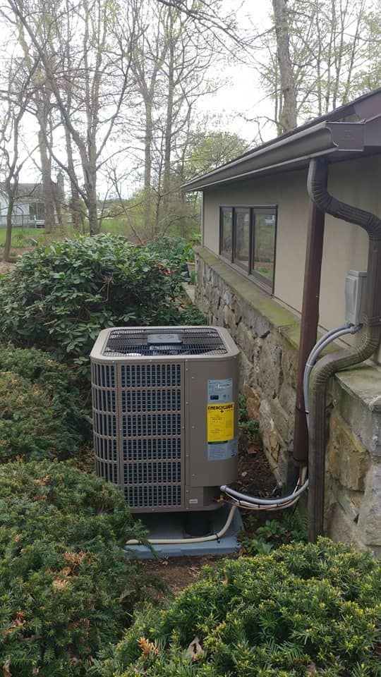 An air conditioner is sitting on the side of a building.