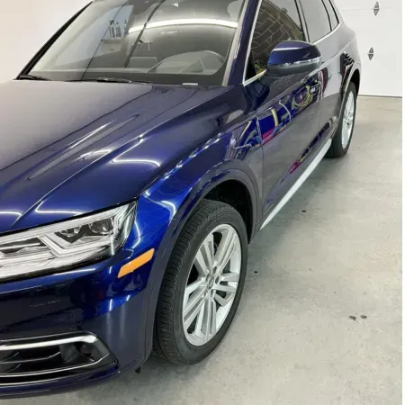 Blue SUV parked indoors in a bright showroom, front-left view.